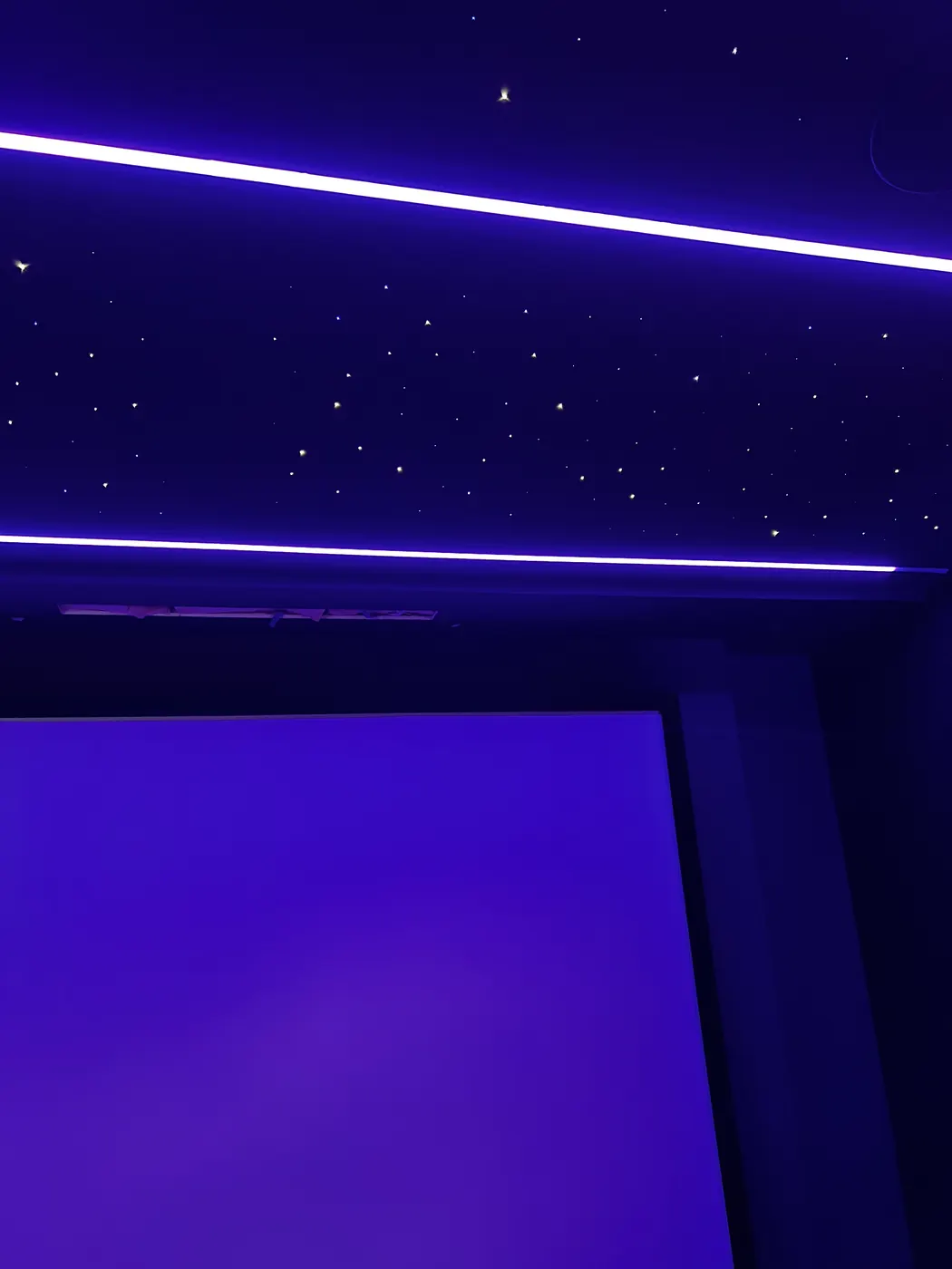 Projection screen under a star ceiling with purple LED lines