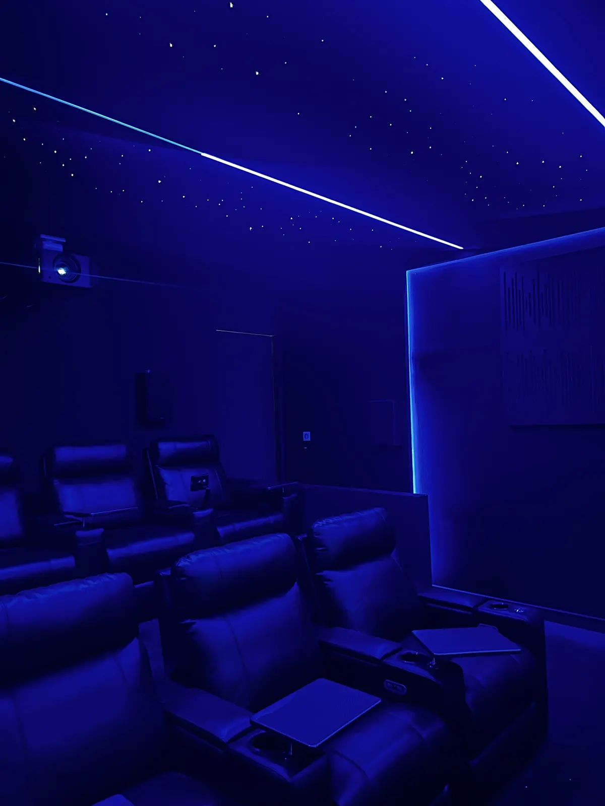Finished theatre with recliners under a glowing star ceiling